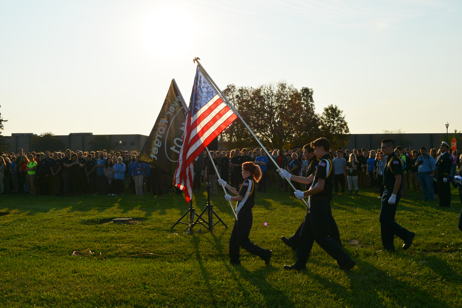 public safety students walk with flags during ceremony